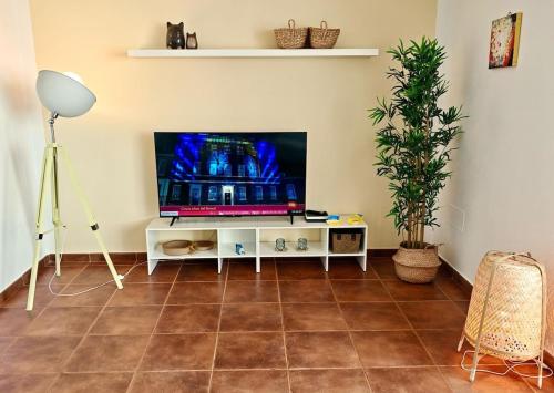 un salon avec une télévision sur une table blanche dans l'établissement Casa Kusama, à Corralejo