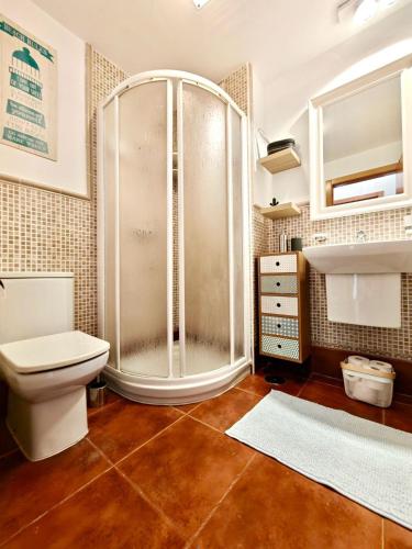 a bathroom with a shower and a toilet and a sink at Casa Kusama in Corralejo