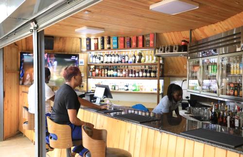 a group of people sitting at a bar at The Giraffe Cottages in Nairobi