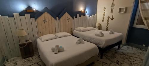 a room with two beds with towels on them at Résidence LE11B in Uzerche