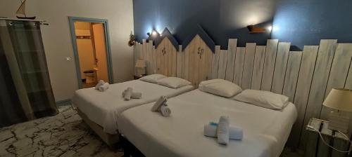 two beds in a hotel room with towels on them at Résidence LE11B in Uzerche