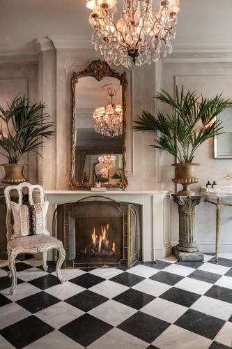 a room with a fireplace and a chair and a mirror at The Notary in Bruges