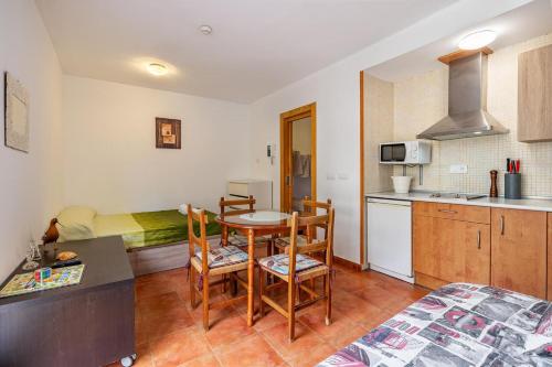 eine Küche mit Tisch und Stühlen in einem Zimmer in der Unterkunft Monte Gorbea Mumu 7 B in Sierra Nevada