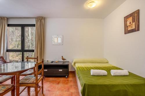 Un dormitorio con una cama, una mesa y un escritorio. en Monte Gorbea Mumu 7 B, en Sierra Nevada