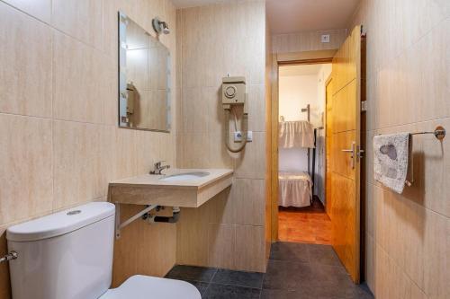 Un baño con inodoro, lavabo y espejo. en Monte Gorbea Mumu 7 B, en Sierra Nevada