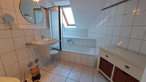a bathroom with a sink and a toilet and a tub at Residenz am Deich NDD 28 in Norden