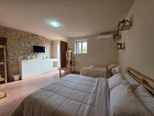 a bedroom with a bed and a tv on a wall at VILLA REGINA - Sperlonga Vertice Rooms in Sperlonga