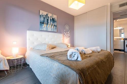 Un dormitorio con una cama grande con toallas. en Clos Vignola - Domaine de la Viva -Superbe vue mer, en Grosseto-Prugna