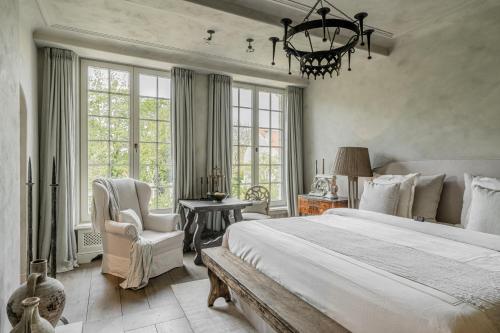 a bedroom with a large bed and a chandelier at The Notary in Bruges