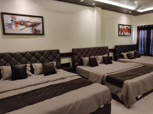 a room with three beds in a room at rudra homestay in Ujjain