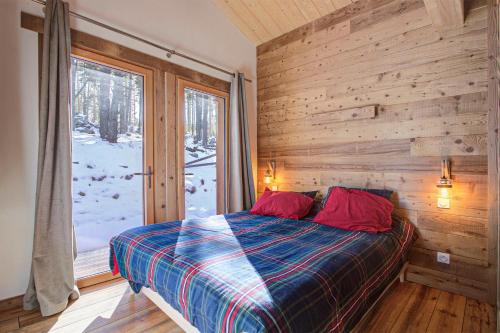 - une chambre avec un mur en bois, un lit et une fenêtre dans l'établissement Les Flocons Dorés - Chalet sur le chemin des pistes, à Formiguères