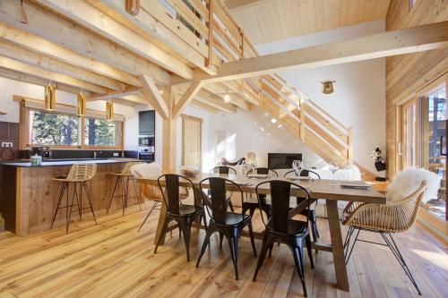 une salle à manger avec une grande table et des chaises en bois dans l'établissement Les Flocons Dorés - Chalet sur le chemin des pistes, à Formiguères
