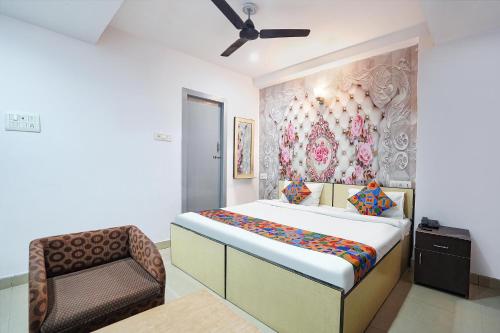 a bedroom with a bed and a chair at FabExpress R Inn - Nr Prayagraj Railway Station in Muthiganj