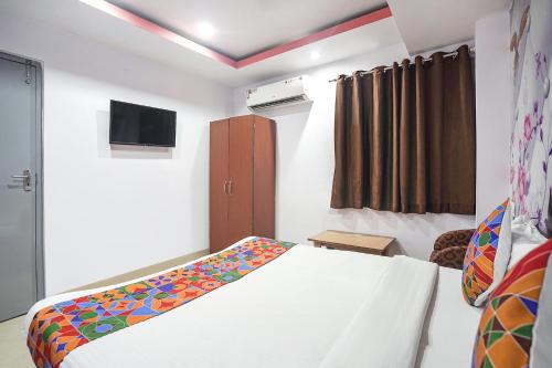 a bedroom with a bed and a tv in it at FabExpress R Inn - Nr Prayagraj Railway Station in Muthiganj