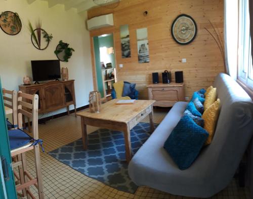 un salon avec un canapé et une table dans l'établissement Le Cocon des Oiseaux, à Lamonzie-Saint-Martin