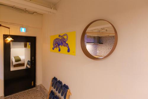 a mirror on a wall next to a room at Hostel Mihojae Seomyeon in Busan