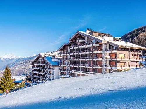 a building on top of a snow covered mountain at Apartment Hauts De Nendaz B OP by Interhome in Nendaz
