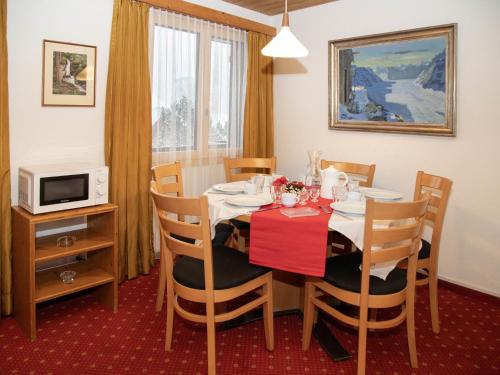 a dining room with a table and chairs and a microwave at Apartment Chalet Abendrot apARTments-29 by Interhome in Grindelwald