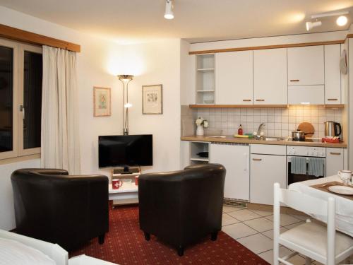 uma cozinha com armários brancos e uma sala de estar em Apartment Chalet Abendrot apARTments-6 by Interhome em Grindelwald