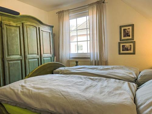 a bedroom with two beds and a large window at Apartment Hus am Bodden by Interhome in Waase