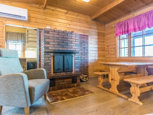 uma sala de estar com lareira, mesa e cadeiras em Holiday Home Aittoniemi i by Interhome em Hopsu