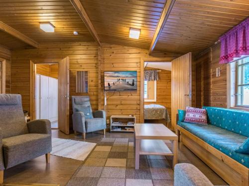 uma sala de estar com um sofá azul e cadeiras em Holiday Home Aittoniemi i by Interhome em Hopsu