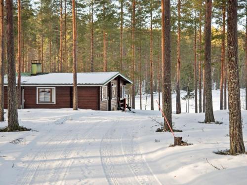 uma cabana de madeira na neve com árvores em Holiday Home Aittoniemi ii by Interhome em Hopsu