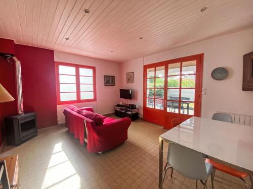 un salon avec un canapé rouge et une table dans l'établissement Holiday Home Les Rougets - TSM217 by Interhome, à La Tranche-sur-Mer