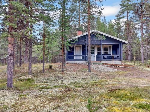 a blue house in the middle of the forest at Holiday Home Tunturitupa kuolpuna by Interhome in Raattama