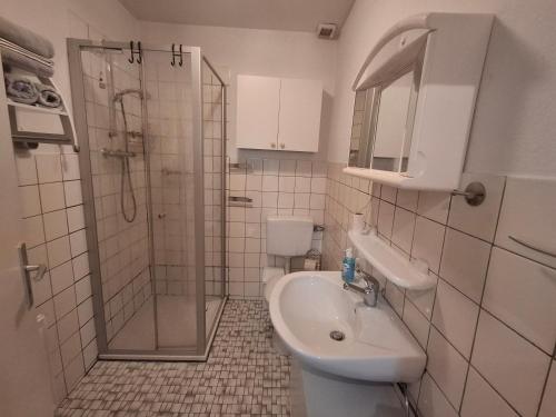 a bathroom with a shower and a sink and a toilet at Ferienwohnung Waldmann 65356 in Moormerland
