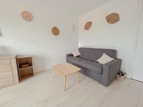 un salon avec un canapé et une table dans l'établissement Charmant studio bohème vue dégagée moderne, à Fréjus