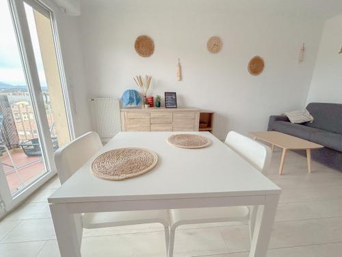 une table blanche et des chaises dans un salon dans l'établissement Charmant studio bohème vue dégagée moderne, à Fréjus