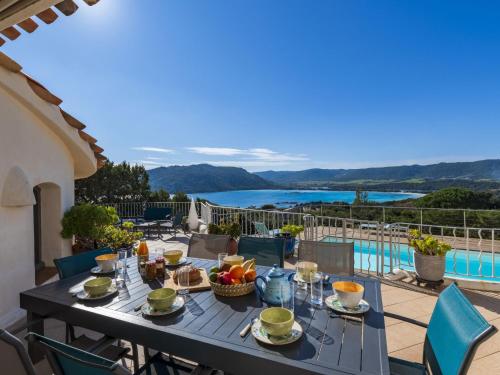 une table sur un balcon avec vue sur l'eau dans l'établissement Villa Villa Sallena by Interhome, à Porto-Vecchio