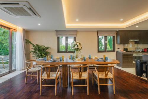 a kitchen and dining room with a wooden table and chairs at Barcelo Coconut Island, Phuket in Phuket Town