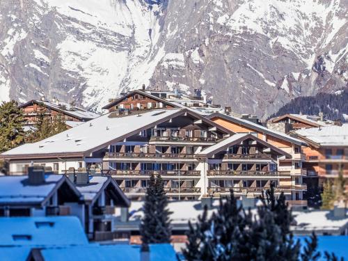 a hotel with a snow covered mountain in the background at Apartment Valaisia 24A by Interhome in Nendaz