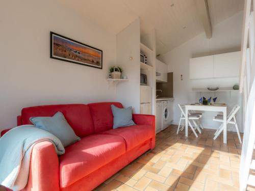 - un canapé rouge dans le salon avec une cuisine dans l'établissement Holiday Home Paradise Océan-16 by Interhome, à Capbreton