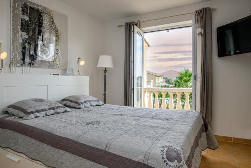 une chambre avec un lit et une grande fenêtre dans l'établissement Domaine Le Clos des Oliviers, à Vidauban