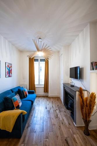 un salon avec un canapé bleu et une cheminée dans l'établissement Le Vauban - Close to downtown Parc Tête d 'Or, à Lyon