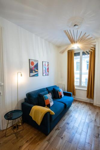 un salon avec un canapé bleu et une table dans l'établissement Le Vauban - Close to downtown Parc Tête d 'Or, à Lyon
