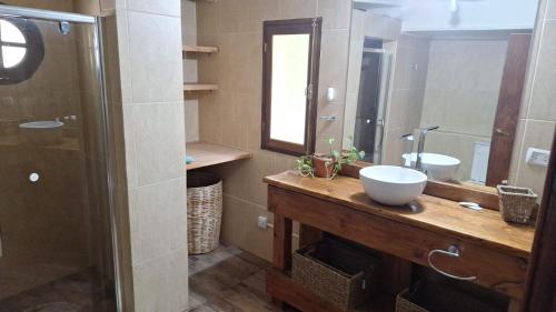 a bathroom with a sink and a mirror and a shower at Departamentos El Bolson in El Bolsón