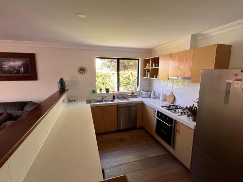 a small kitchen with a sink and a refrigerator at Alella by the sea in Gnarabup