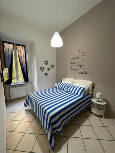 ein Schlafzimmer mit einem Bett mit einer blau-weiß gestreiften Decke in der Unterkunft Casa MaVi in Neapel