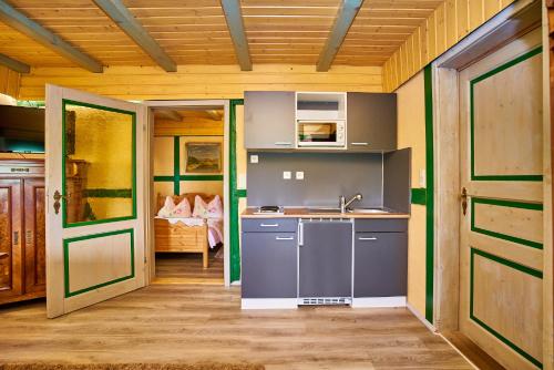 a kitchen with a sink and a stove in a room at Hotel Olbernhau mit Sauna - Kleines Landhotel zur Ofenschenke in Olbernhau