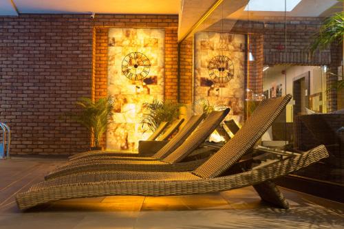 a group of chairs in front of a wall with a clock at HOTEL ALMOND BUSINESS & SPA BY GRANO - GRANO HOTEL Gdańsk Riverside in Gdańsk