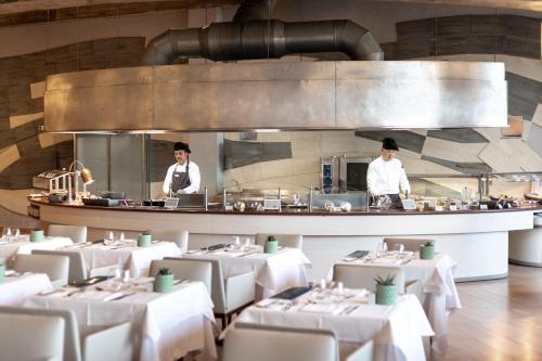 two chefs in a restaurant kitchen with white tables at MUR Faro Jandia Fuerteventura & Spa in Morro del Jable