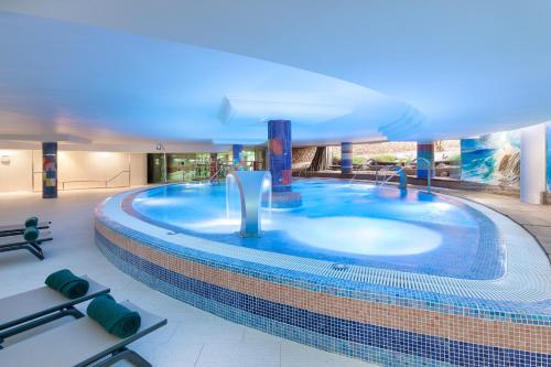 a large swimming pool in the middle of a building at MUR Faro Jandia Fuerteventura & Spa in Morro del Jable