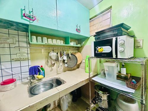 a kitchen with a sink and a microwave at Montalban GuestHouse 2 AC BR 4pax 200mbps WiFi FREE Netflix Shower Heater Parking in Rodriguez