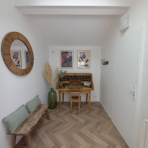 Cette chambre comprend une table, un banc et un miroir. dans l'établissement La Maunia Studio, à Montceaux