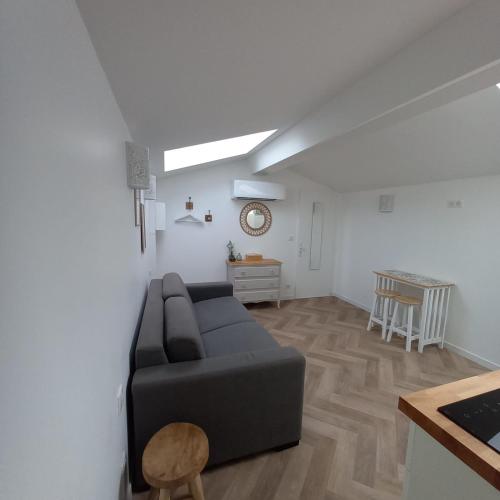 un salon avec un canapé noir et une table dans l'établissement La Maunia Studio, à Montceaux