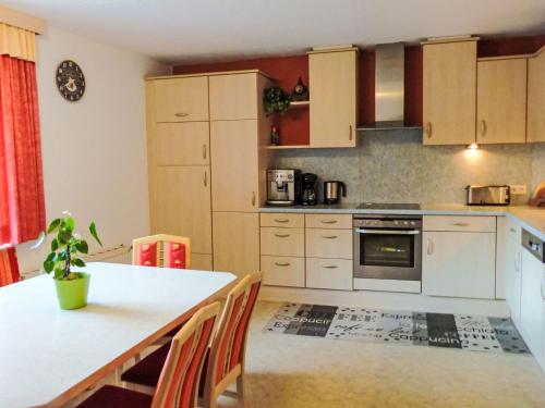 a kitchen with a table and a table and chairs at Apartment Winklerhof - Bergblick by Interhome in Oetz